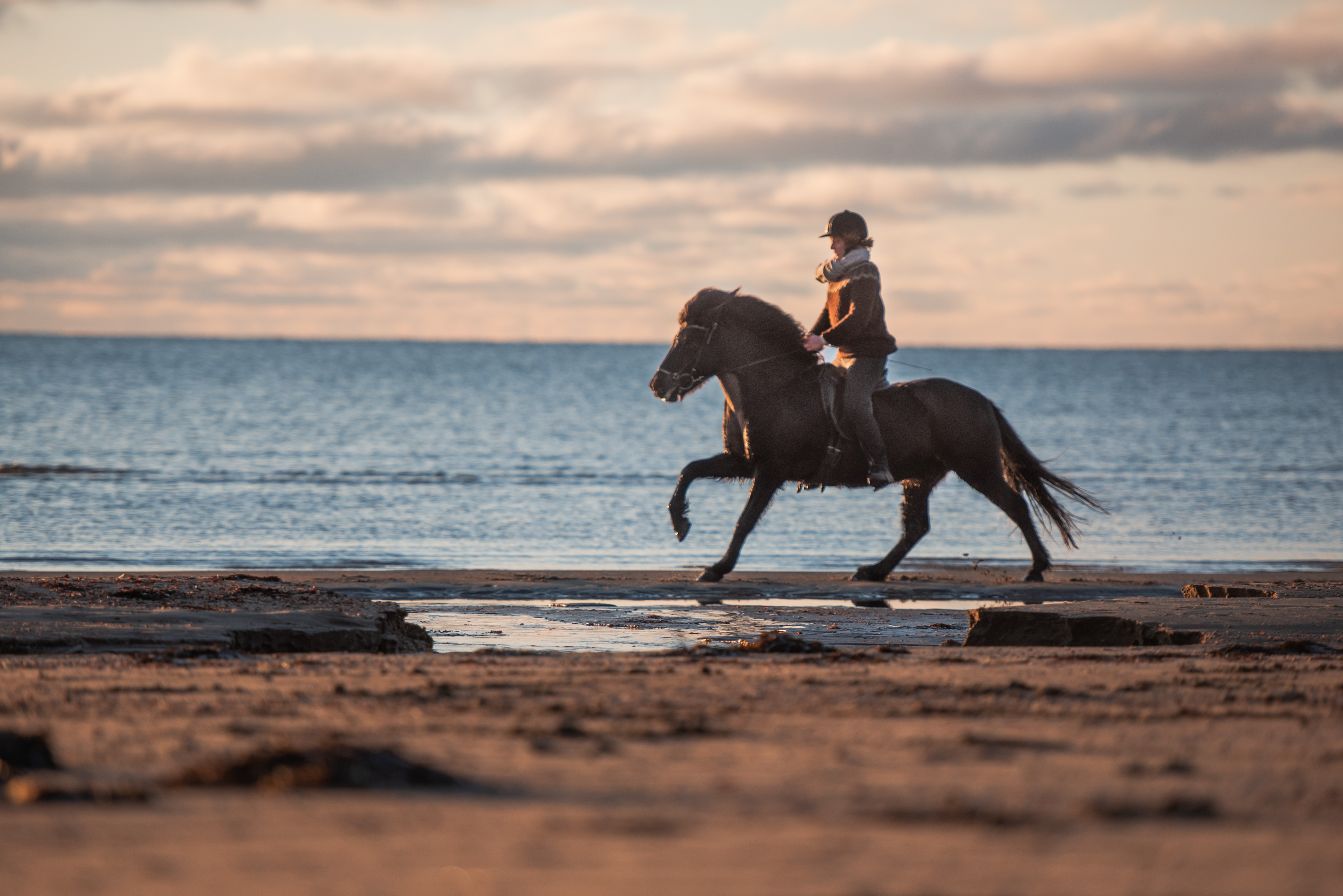Flicka rider på stranden
